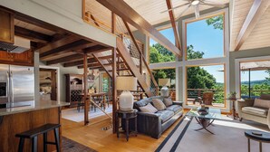 Un interior espacioso con cocina, comedor y sala de estar, con amplias ventanas y vigas de madera.