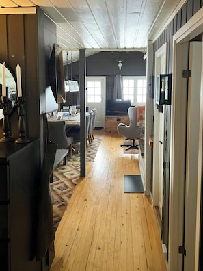 A room with a wooden floor, a dining table with chairs, a television, and a window with curtains. - Mountain cabin by ski trails in southern Blefjell (Kongsberg)