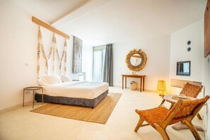 A bedroom with a bed, bedside table, lamp, chair, and a decorative mirror. - Villa Le Belvedere (Tangier)