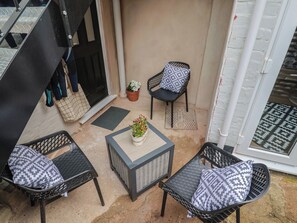 A patio with two wicker chairs, a small table, and a potted plant. - Flat 1 Harley House (Sidmouth)