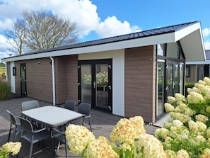 Een modern gebouw met een patio, een tafel en stoelen.