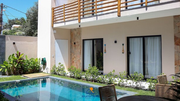 Un hôtel moderne doté d’une piscine, d’un espace extérieur aménagé et d’un balcon.