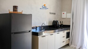 Une cuisine moderne équipée d’un réfrigérateur, d’un évier et d’une machine à café.
