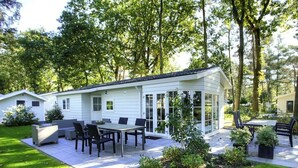 A white house with a patio, outdoor seating, and a garden. - Holiday Home in Otterlo With Terrace (Otterlo)