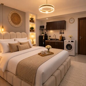 Un dormitorio moderno con una cama grande, mesitas de noche, un armario empotrado y una kitchenette compacta.