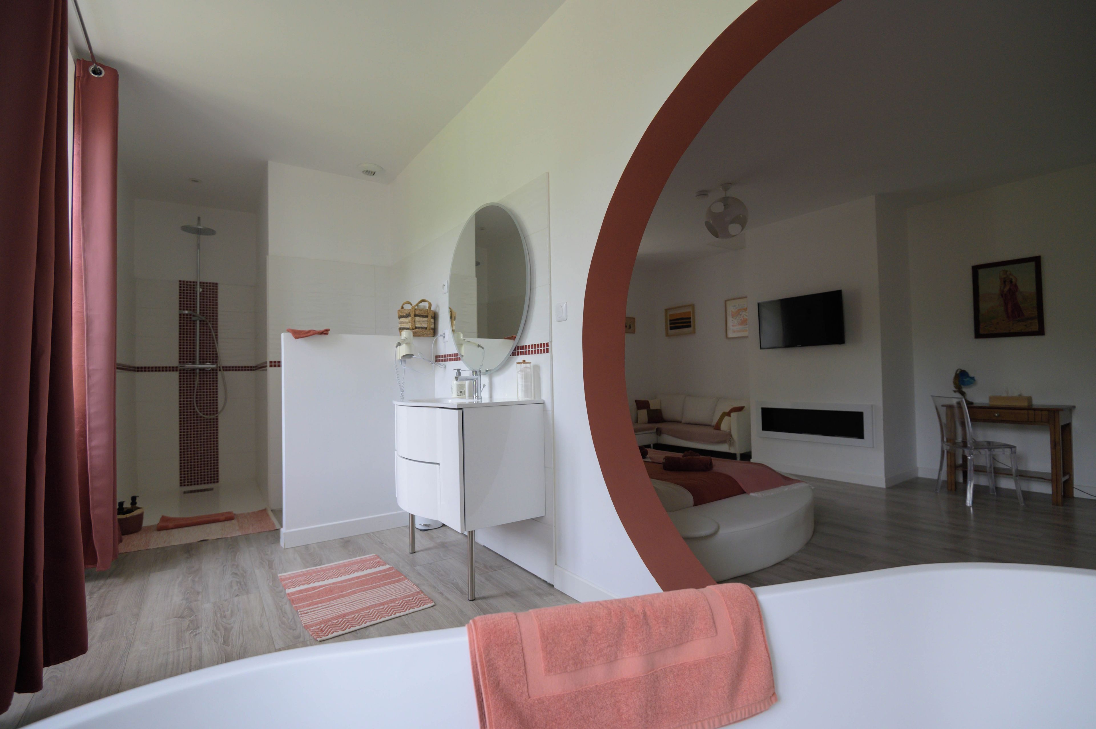 Une salle de bain moderne équipée d’une baignoire, d’une douche et d’un meuble-lavabo avec un miroir.