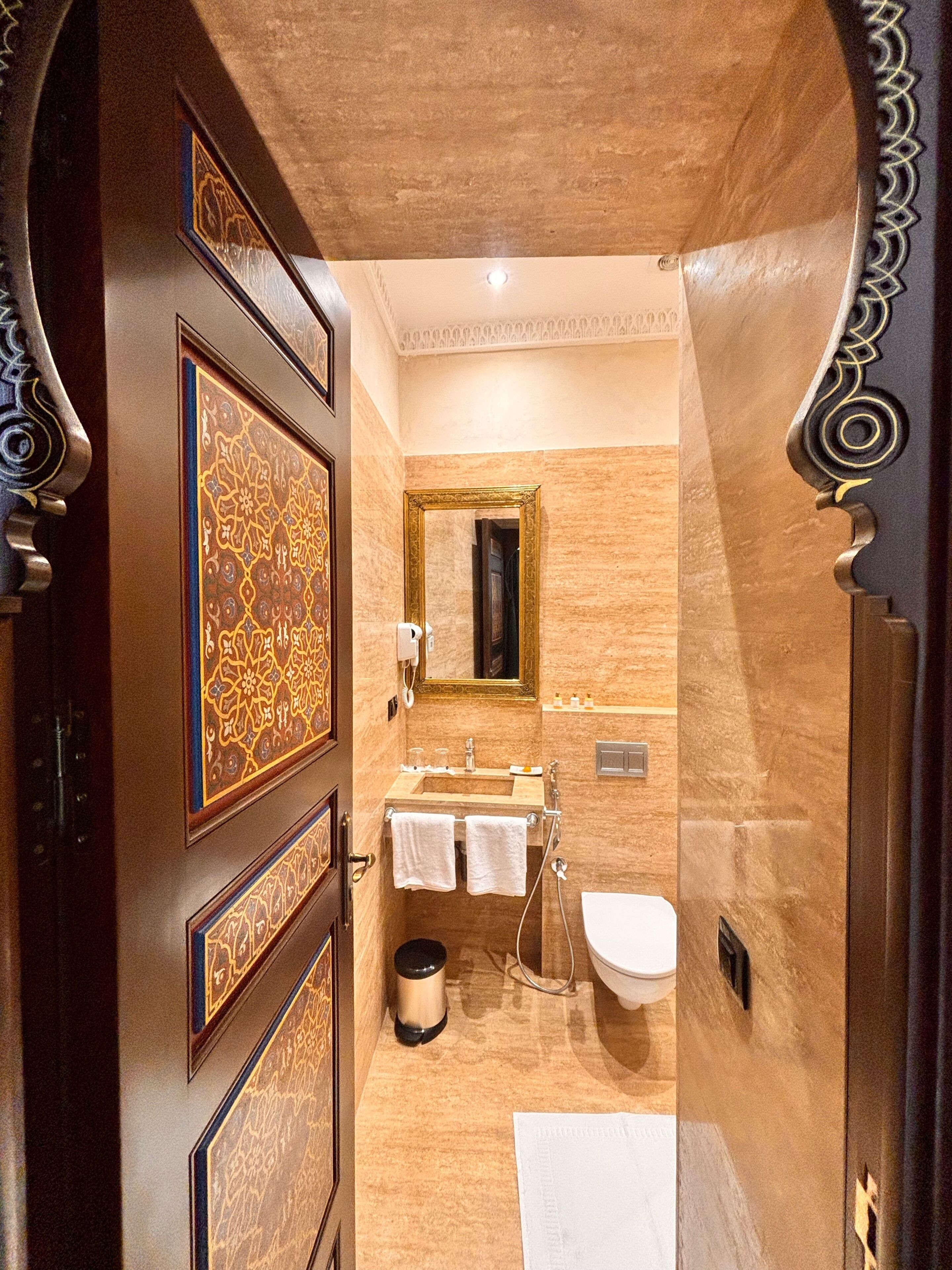A bathroom with a sink, mirror, and towel rack.