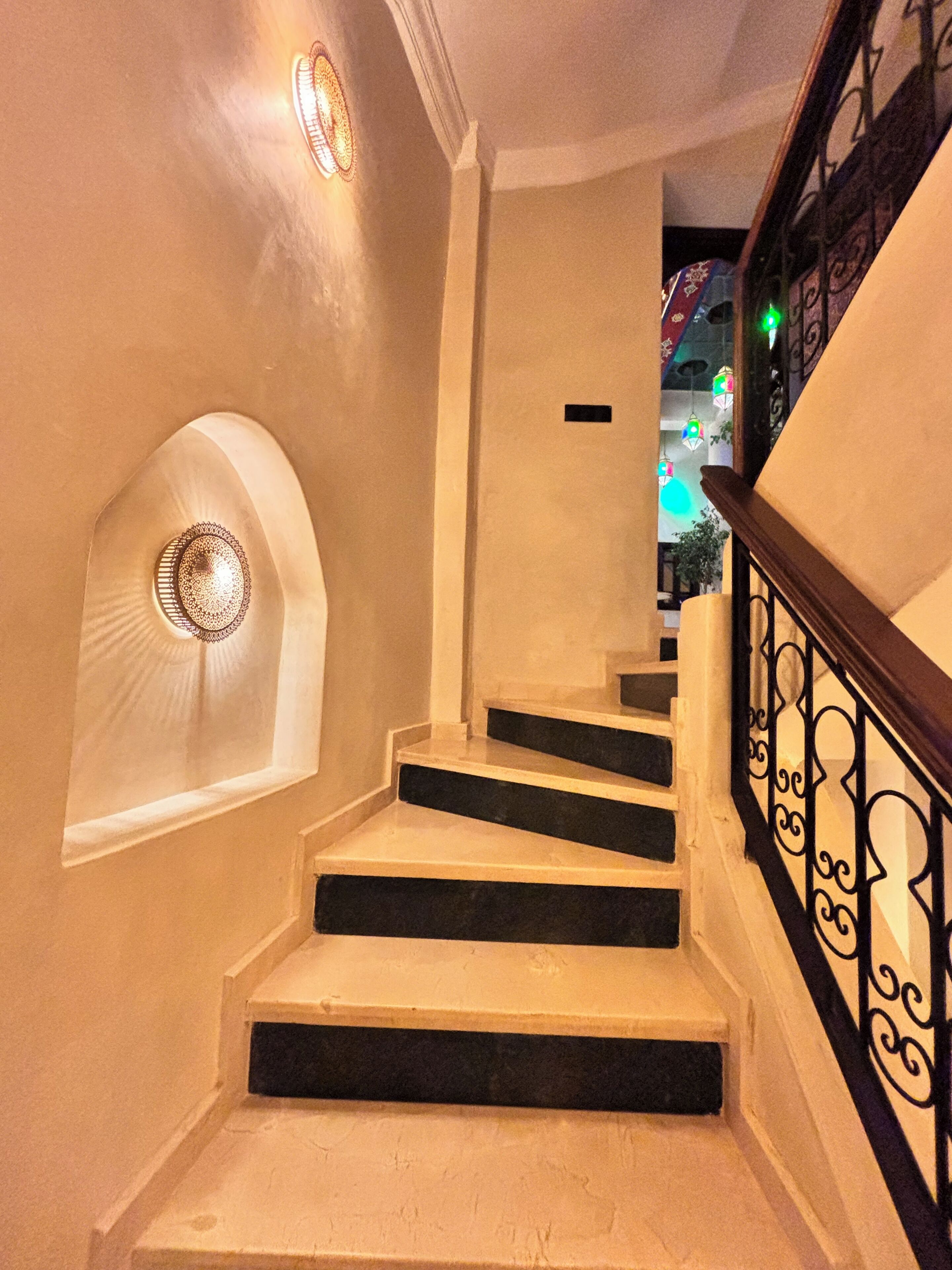 A staircase with a handrail and a wall-mounted light fixture.