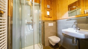 Ein Badezimmer mit Duschkabine, Toilette und Waschbecken.