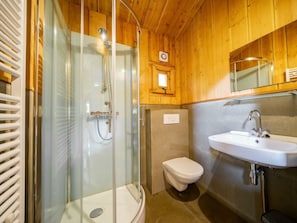 Ein Badezimmer mit Duschkabine, Toilette und Waschbecken.