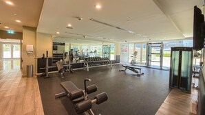 Una palestra con attrezzature per l'allenamento, ampie finestre e un design moderno e pulito.