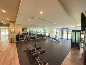 A gym with exercise equipment, large windows, and a clean, modern design. - Luxury 1BR, Business Bay, Burj Khalifa Peek View (Dubai)