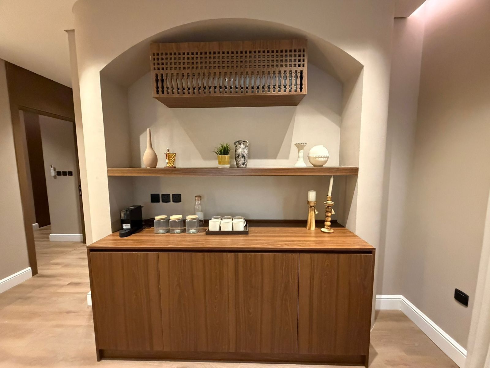 Une console en bois agrémentée d’objets décoratifs et surmontée d’une étagère.