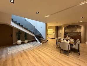 Un interior moderno con una escalera, comedor y cocina.