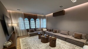 Ein modernes Wohnzimmer mit einer Eckcouch, einem gemusterten Teppich und einem Couchtisch.
