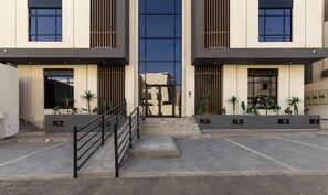 Un edificio moderno con una entrada central, varias ventanas y una escalera que lleva a la entrada.