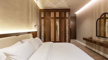 Een moderne hotelkamer met een groot bed, een houten scheidingswand en een spiegel aan de muur.