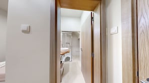 A hallway leading to a bathroom with a sink and shower. - Lobster Room - Coral (Albufeira)