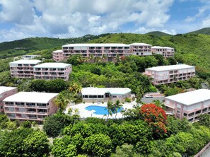 A resort with multiple buildings, a central pool, and lush greenery. - Brand New to VRBO-New Booking Discount-Gorgeous Sea Views, Generator, Wifi, Pool (Christiansted)