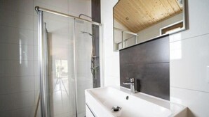A modern bathroom with a glass shower enclosure, a white sink, and a wooden ceiling. - Holiday Home in Otterlo With Terrace (Otterlo)