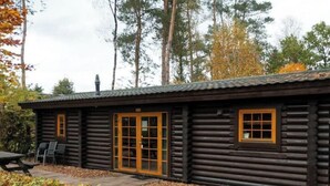 A log cabin with a patio, a dining table, and chairs. - Holiday Home in Otterlo With Terrace (Otterlo)