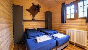 A cabin with two beds, a window, and a mounted animal head. - Holiday Home in Otterlo With Terrace (Otterlo)