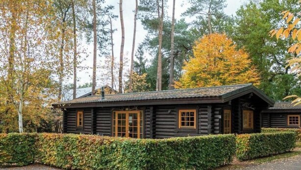 A log cabin with a symmetrical design, a central door, and evenly spaced windows. - Holiday Home in Otterlo With Terrace (Otterlo)