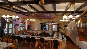 A dining area with round tables, chairs, and hanging decorations.