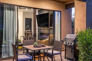 An outdoor patio with a dining table, chairs, a grill, and a sliding glass door leading to an interior space. - Villa 4 at Troon North, Luxury Golf Retreat with Pool Table (Scottsdale)
