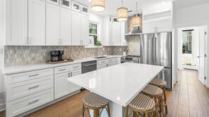 A modern kitchen with white cabinetry, stainless steel appliances, a large island with stools, and pendant lighting. - NEW LISTING - Completely remodeled with new pics coming soon. (Seacrest Beach)