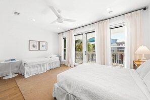A bedroom with a large bed, two bedside tables, a ceiling fan, and a view of the outside. - NEW LISTING - Completely remodeled with new pics coming soon. (Seacrest Beach)