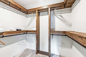 Ein Raumeck mit einer hölzernen Bank, einem Kleiderständer und einem Spiegel.