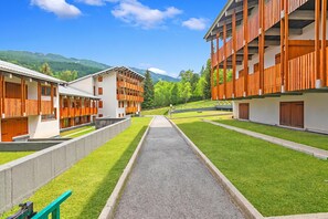 A modern hotel with a central pathway, wooden balconies, and a mountain backdrop. - L'anemone Near Campo Smith Lifts (Bardonecchia)