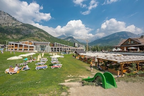 Ein Resort mit Poolbereich, Sitzgelegenheiten im Freien und Bergblick.