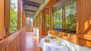 A wooden deck with a table set for breakfast, overlooking a forest. - L'anemone Near Campo Smith Lifts (Bardonecchia)