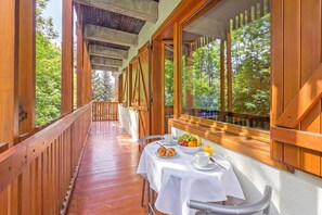A wooden deck with a table set for breakfast, overlooking a forest. - L'anemone Near Campo Smith Lifts (Bardonecchia)