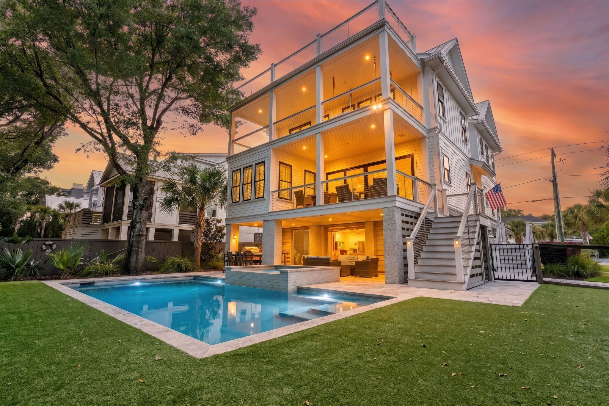 A two-story house with a swimming pool, outdoor seating, and a staircase leading to the upper level.