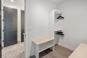 A small, well-lit room with a bench, a coat rack, and a door leading to another room. - Villa 1 at Troon North, Luxury Golf Retreat with Pool Table (Scottsdale)