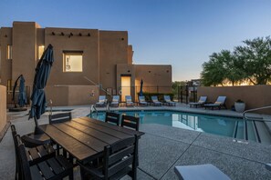 A rooftop pool area with lounge chairs and a table, surrounded by a building with a flat facade. - Villa 1 at Troon North, Luxury Golf Retreat with Pool Table (Scottsdale)