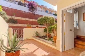 A courtyard with potted plants, a door, and a tiled floor. - Conde Sunset View (Costa Adeje)