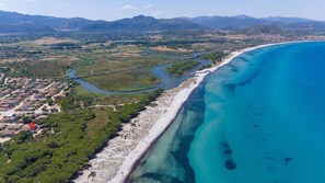 Luftaufnahme einer Küstenregion mit Fluss, Strand und Wohngebiet.