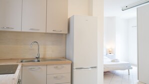 Una cocina moderna con un lavamanos, armarios y un refrigerador.