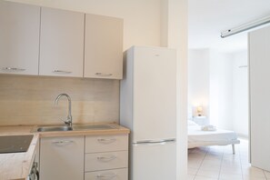 Eine moderne Küche mit Spüle, Schränken und einem Kühlschrank.
