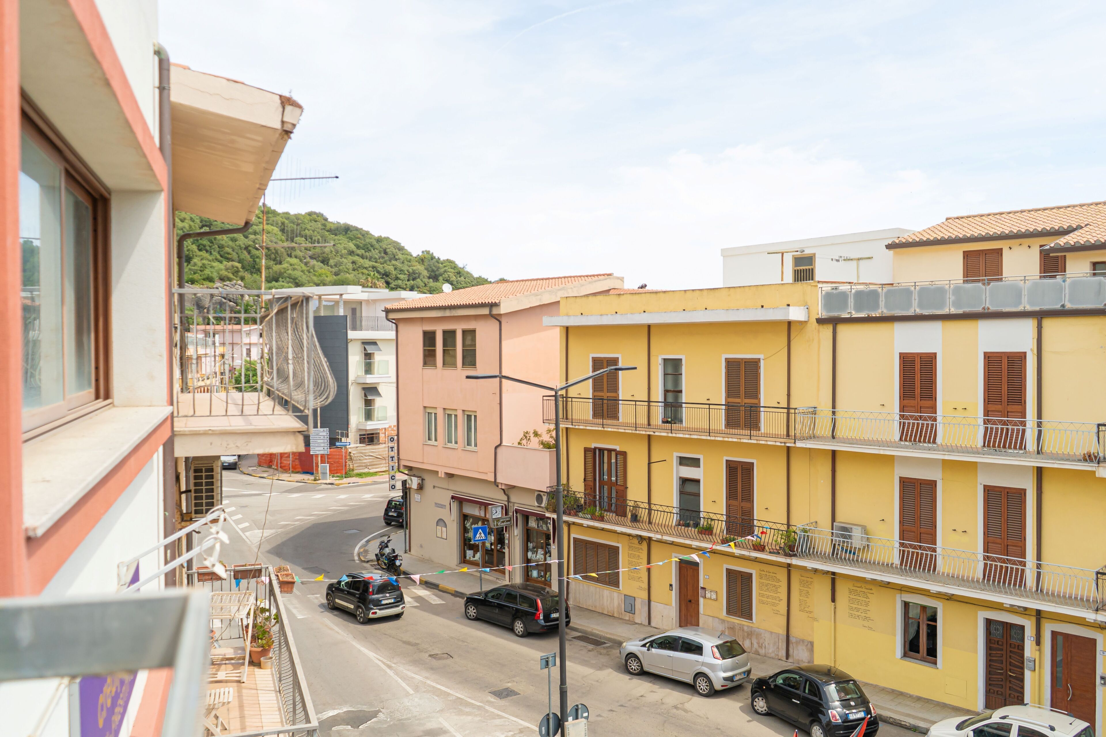 Vista de una calle con edificios, coches y un cielo despejado.