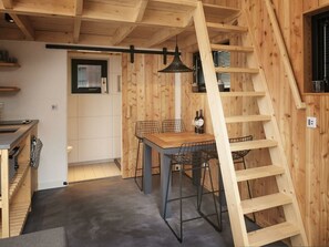 Ein Holzinnenraum mit Essbereich, Treppe und Küche.