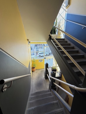 Eine Treppe mit Metallgeländern, einem Blumentopf und einem Schild an der Wand.