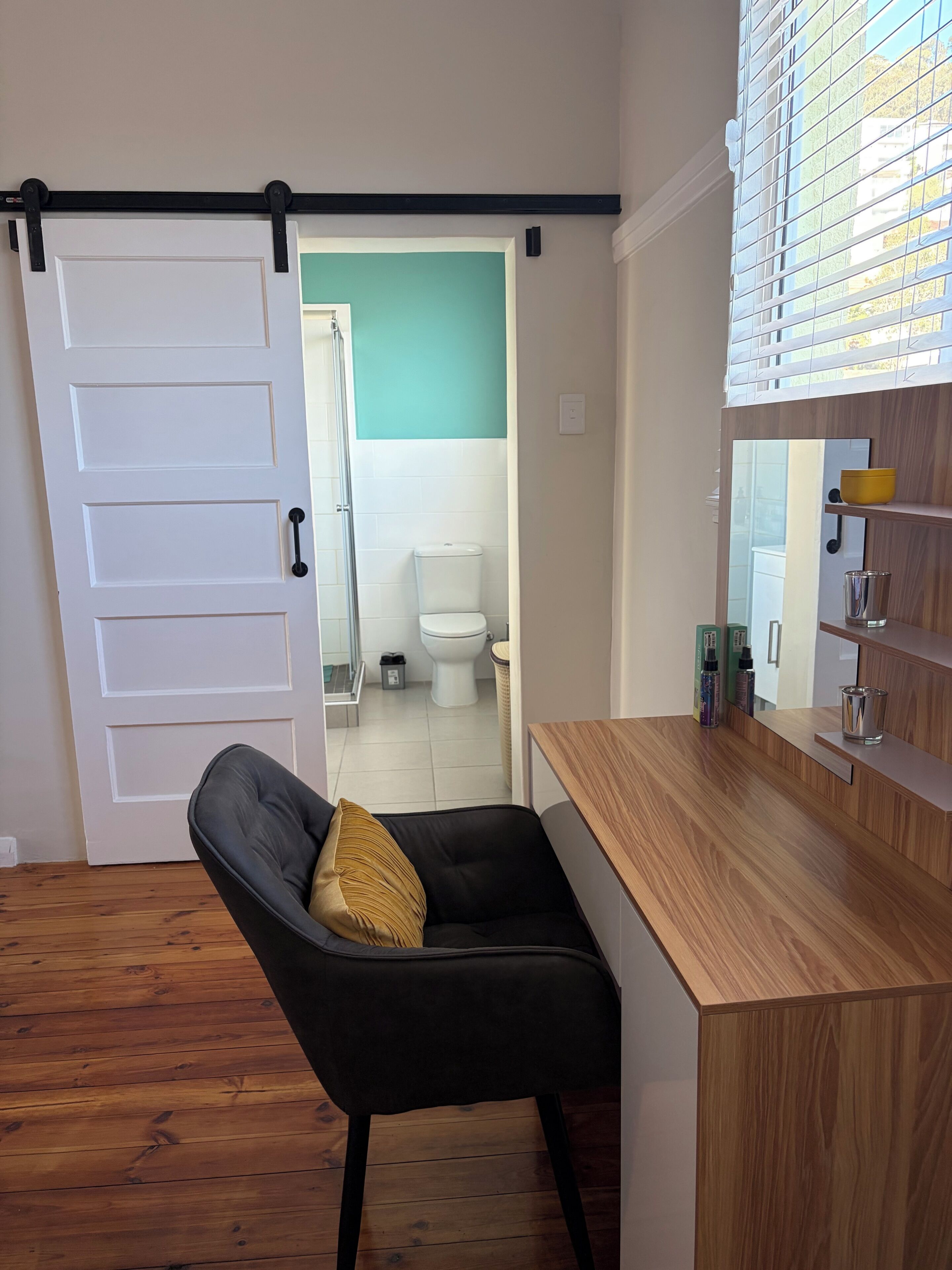 A modern bathroom with a toilet, a sink with a mirror, and a shower area.