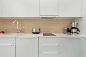 A modern kitchen with a sink, a kettle, a coffee maker, and a toaster. - Cozy Studios Near the Beach | Parking (Pobierowo)