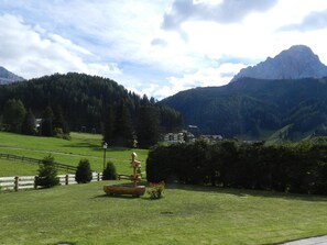 Eine Rasenfläche mit Holzzaun, Vogelhaus und Bank.