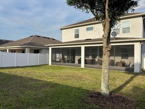 Ein zweistöckiges Haus mit überdachter Terrasse.
